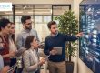 Team meeting analyzing data on digital screen at FrontPage Interactive